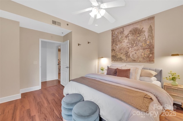 bedroom featuring wood finished floors, a ceiling fan, and baseboards