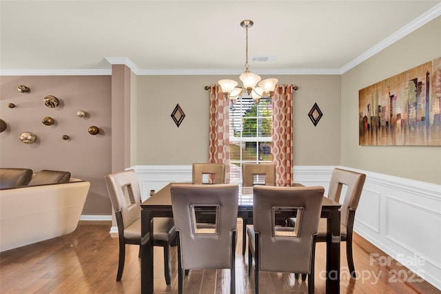 12217 Dearview Ln, Charlotte, NC 28269 - dining room with a chandelier, wood finished floors, ornamental molding, and a wainscoted wall
