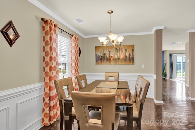 12217 Dearview Ln, Charlotte, NC 28269 - dining space with a chandelier, crown molding, wainscoting, wood finished floors, and a decorative wall