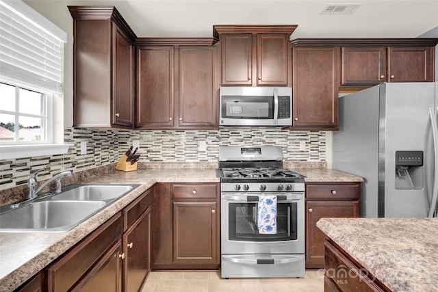 12217 Dearview Ln, Charlotte, NC 28269 - kitchen featuring appliances with stainless steel finishes, a sink, backsplash, and light countertops