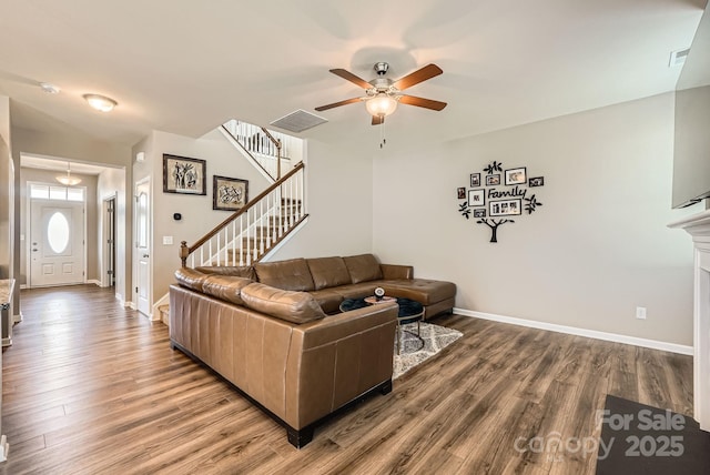 living room with ceiling fan, wood finished floors, stairway, and baseboards