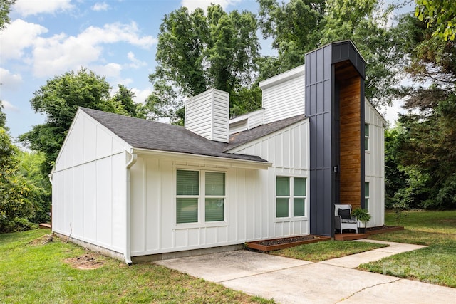 6824 Cortez Trl, Charlotte, NC 28227 - view of home's exterior featuring a chimney, roof with shingles, a lawn, and board and batten siding