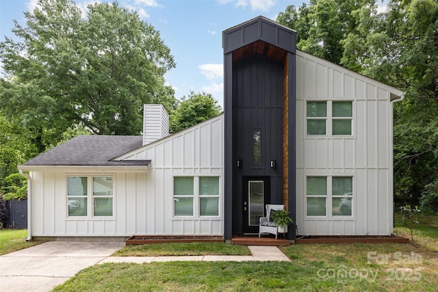 6824 Cortez Trl, Charlotte, NC 28227 - view of front of house with board and batten siding, a chimney, and roof with shingles