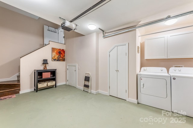 garage with independent washer and dryer, a garage door opener, and baseboards