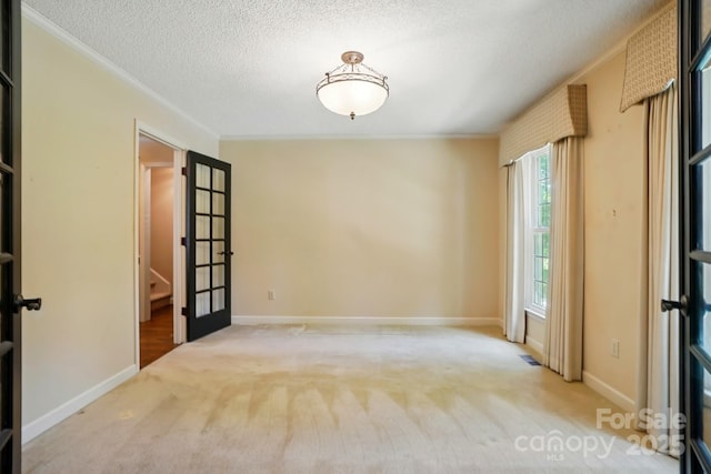 1295 Patterson St, China Grove, NC 28023 - empty room featuring crown molding, a textured ceiling, carpet floors, french doors, and baseboards