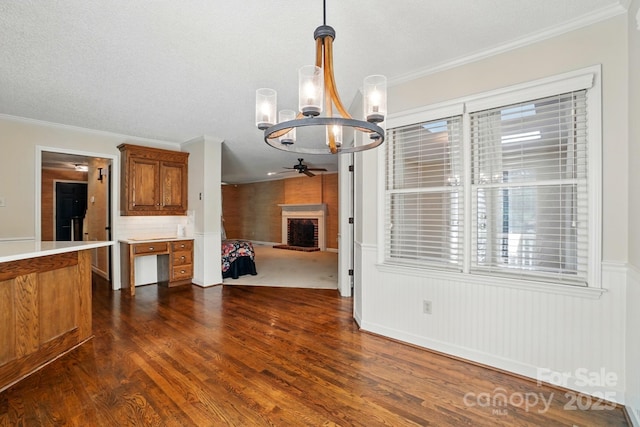 1295 Patterson St, China Grove, NC 28023 - unfurnished living room featuring a chandelier, ceiling fan, dark wood-type flooring, crown molding, and a fireplace
