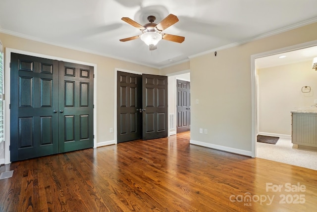 1295 Patterson St, China Grove, NC 28023 - unfurnished bedroom featuring crown molding, wood finished floors, two closets, and baseboards