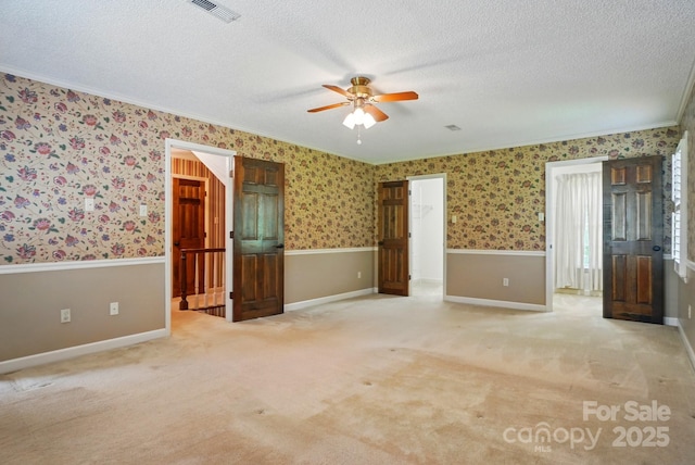 1295 Patterson St, China Grove, NC 28023 - unfurnished bedroom with ornamental molding, a textured ceiling, wallpapered walls, carpet flooring, and a wainscoted wall
