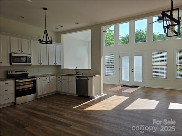 1111 Unionville Church Rd, Monroe, NC 28110 - kitchen featuring appliances with stainless steel finishes, a sink, white cabinets, dark wood-style floors, and pendant lighting