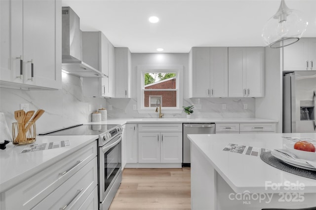 1829 Jennings St, Charlotte, NC 28216 - kitchen featuring wall chimney range hood, stainless steel appliances, a sink, light countertops, and backsplash