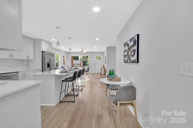 1829 Jennings St, Charlotte, NC 28216 - kitchen featuring stainless steel appliances, recessed lighting, light countertops, light wood-type flooring, and a kitchen breakfast bar
