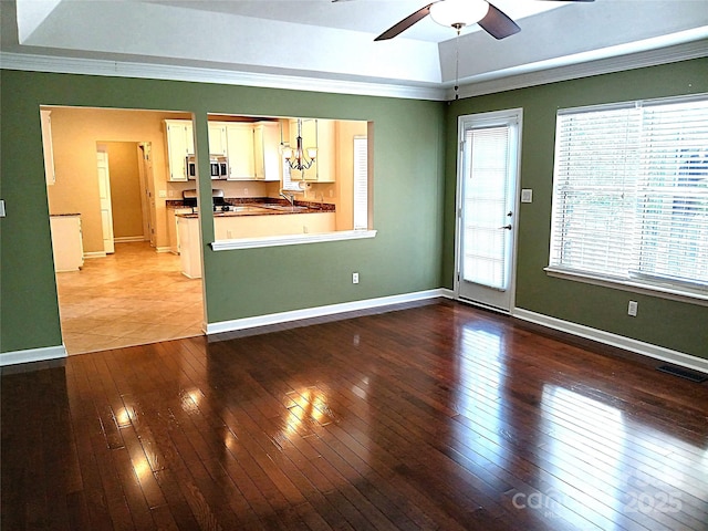 12304 Sandringham Pl, Charlotte, NC 28262 - unfurnished living room featuring a ceiling fan, light wood-type flooring, baseboards, ornamental molding, and a sink