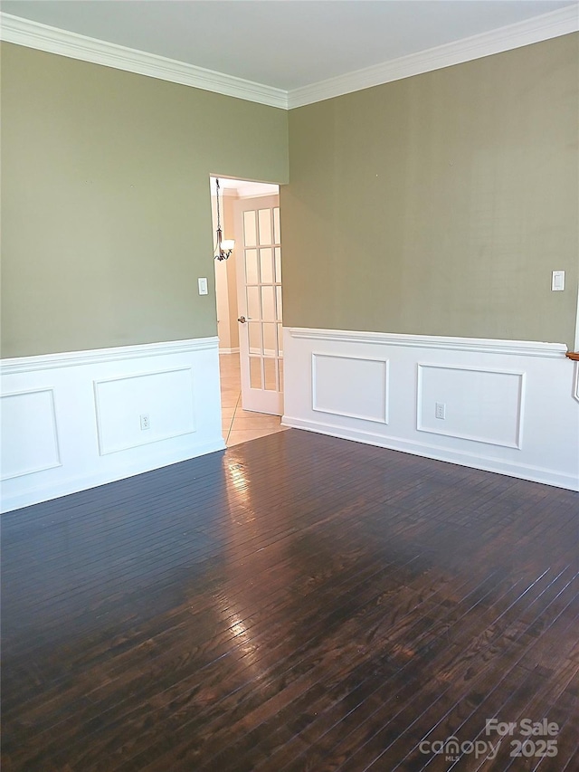 12304 Sandringham Pl, Charlotte, NC 28262 - empty room with wainscoting, hardwood / wood-style floors, ornamental molding, french doors, and a decorative wall