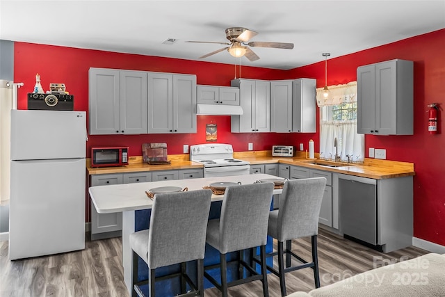 35 Telephone Exchange Rd, Hickory, NC 28601 - kitchen featuring white appliances, a sink, a ceiling fan, light wood finished floors, and a breakfast bar area