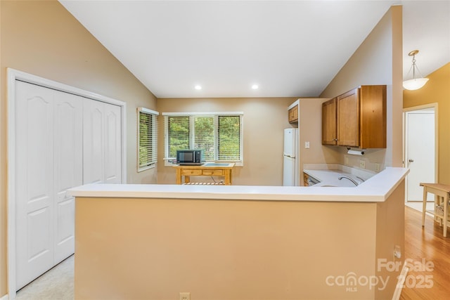 30 Robin Ln, Asheville, NC 28806 - kitchen featuring vaulted ceiling, freestanding refrigerator, brown cabinetry, a peninsula, and light countertops