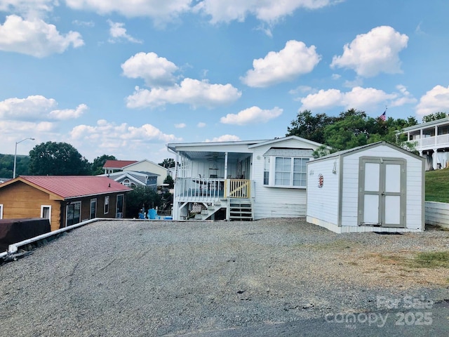 108 Brit Ln, New London, NC 28127 - manufactured / mobile home with a storage unit, an outbuilding, ceiling fan, and a porch