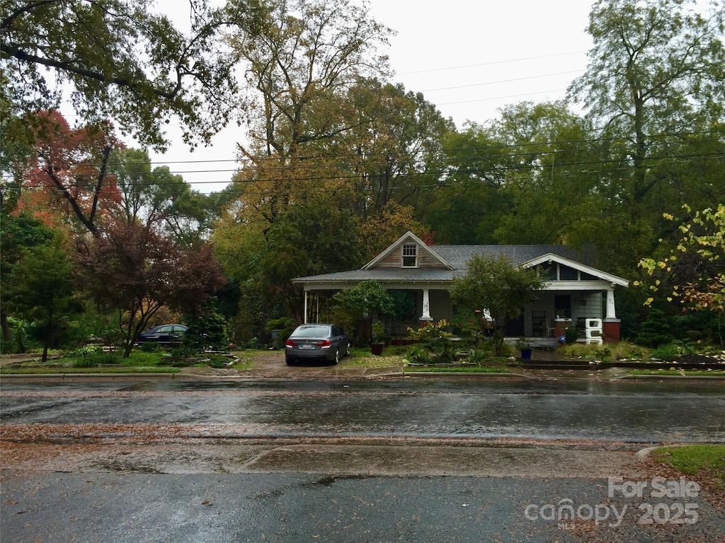 view of front facade with asphalt driveway and a carport