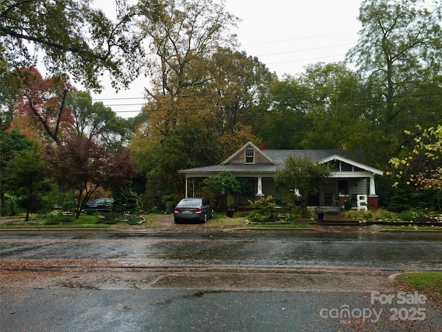view of front facade with asphalt driveway and a carport