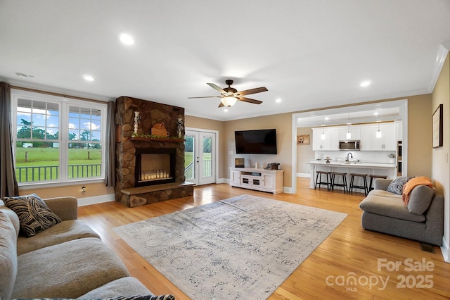 3707 Seagrave Farm Rd, Concord, NC 28025 - living room with a ceiling fan, crown molding, a fireplace, light wood-style flooring, and baseboards