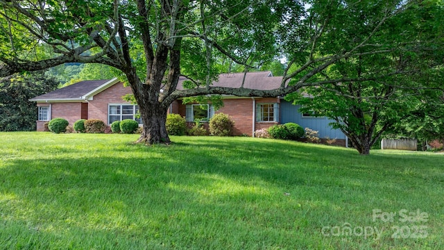 single story home featuring brick siding and a front lawn