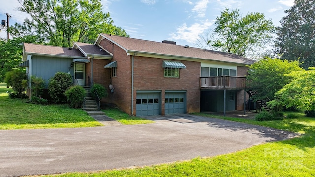view of front of property with a garage, asphalt driveway, brick siding, stairway, and a front lawn