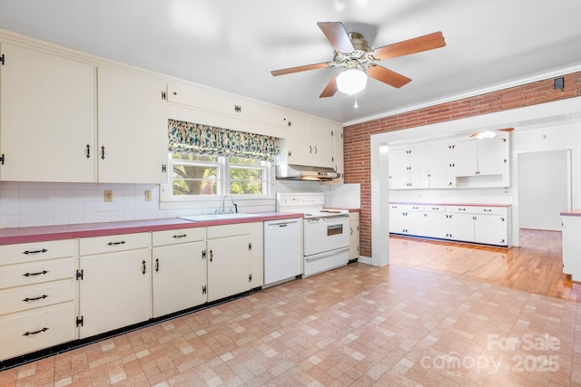 kitchen featuring white appliances, a ceiling fan, a sink, under cabinet range hood, and brick patterned flooring