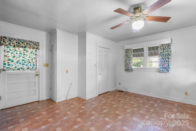 unfurnished bedroom featuring brick patterned flooring, crown molding, baseboards, and a ceiling fan