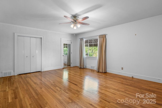 unfurnished bedroom with light wood finished floors, baseboards, and ceiling fan