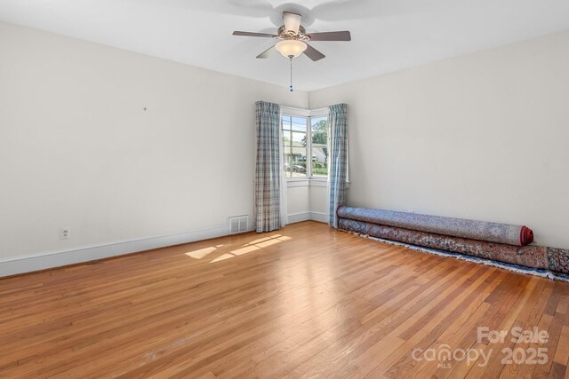 empty room with light wood-type flooring, baseboards, and ceiling fan