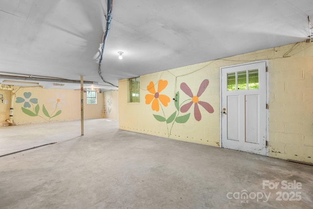 below grade area featuring healthy amount of natural light and concrete block wall
