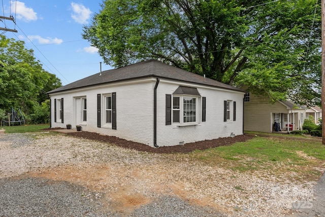 207 Eden St, Davidson, NC 28036 - view of home's exterior featuring a trampoline, brick siding, and roof with shingles