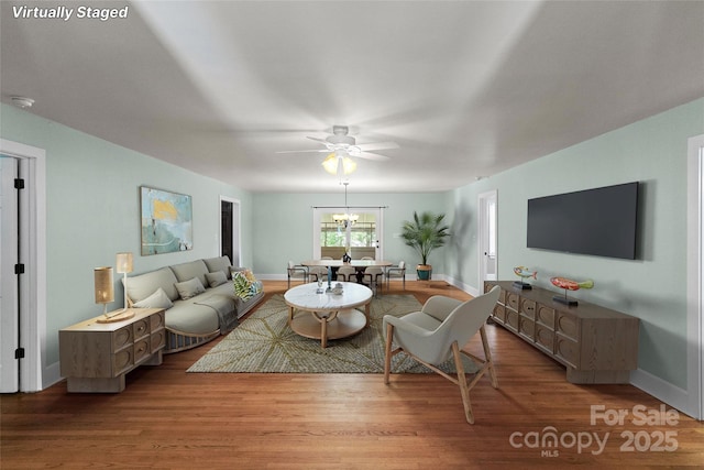 8024 Bradford Ln, Denver, NC 28037 - living room featuring ceiling fan, wood finished floors, baseboards, and a chandelier