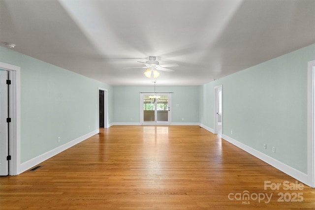 8024 Bradford Ln, Denver, NC 28037 - unfurnished room with a ceiling fan, light wood-style floors, a chandelier, baseboards, and a smoke detector