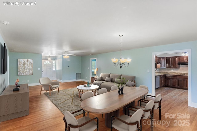 8024 Bradford Ln, Denver, NC 28037 - dining room with light wood-type flooring, baseboards, a chandelier, and a ceiling fan