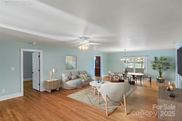 8024 Bradford Ln, Denver, NC 28037 - living room with a chandelier, baseboards, light wood-type flooring, and a ceiling fan