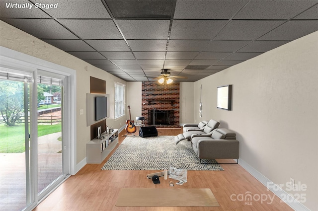 8024 Bradford Ln, Denver, NC 28037 - living area featuring a paneled ceiling, wood finished floors, a fireplace, ceiling fan, and baseboards
