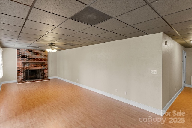 8024 Bradford Ln, Denver, NC 28037 - unfurnished living room featuring wood finished floors, a drop ceiling, a fireplace, ceiling fan, and baseboards