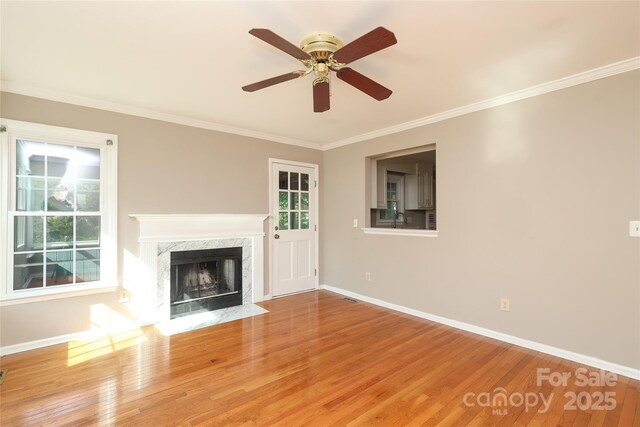 9315 Pebble Creek Way, Charlotte, NC 28269 - unfurnished living room featuring ornamental molding, baseboards, light wood finished floors, a premium fireplace, and a ceiling fan