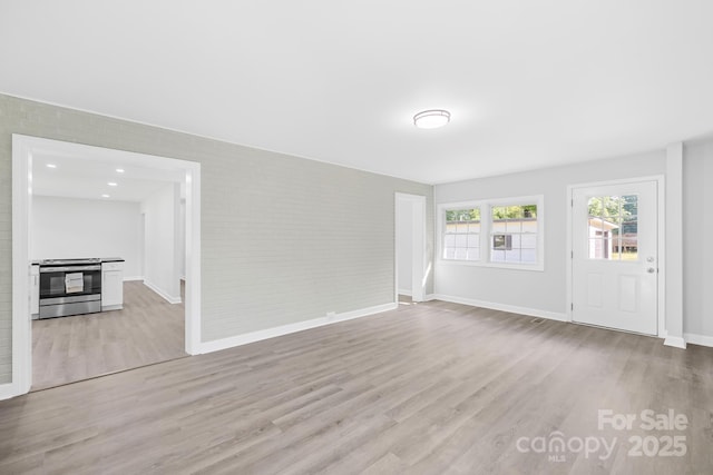 1408 Delview Rd, Cherryville, NC 28021 - unfurnished living room with light wood-style flooring and brick wall
