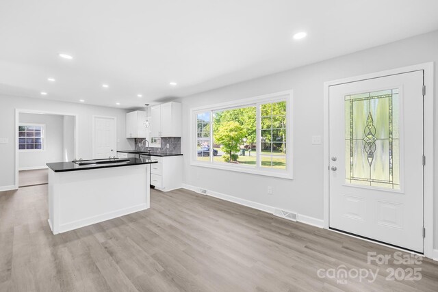 1408 Delview Rd, Cherryville, NC 28021 - kitchen featuring white cabinets, dark countertops, light wood finished floors, recessed lighting, and decorative backsplash
