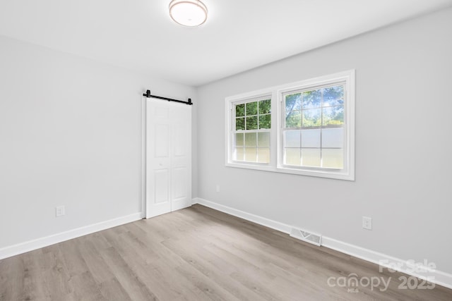 1408 Delview Rd, Cherryville, NC 28021 - unfurnished bedroom with a barn door, wood finished floors, and a closet