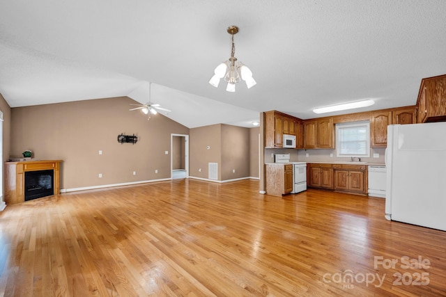 5678 Cedar Run Dr, Denver, NC 28037 - kitchen featuring white appliances, a chandelier, light countertops, light wood-style flooring, and lofted ceiling