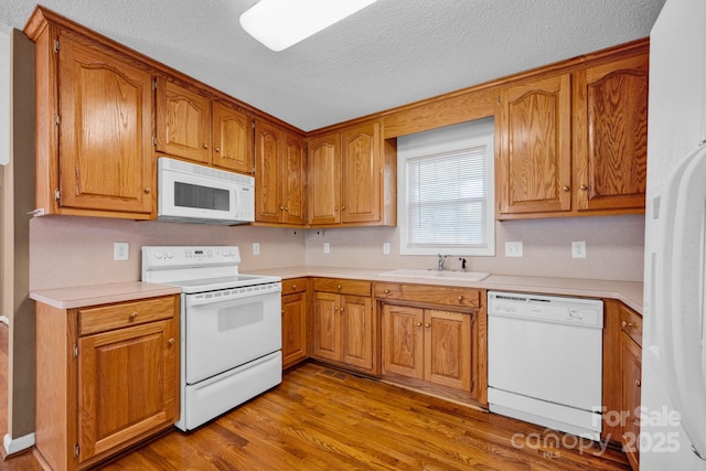 5678 Cedar Run Dr, Denver, NC 28037 - kitchen featuring white appliances, a sink, light wood-style floors, light countertops, and a textured ceiling