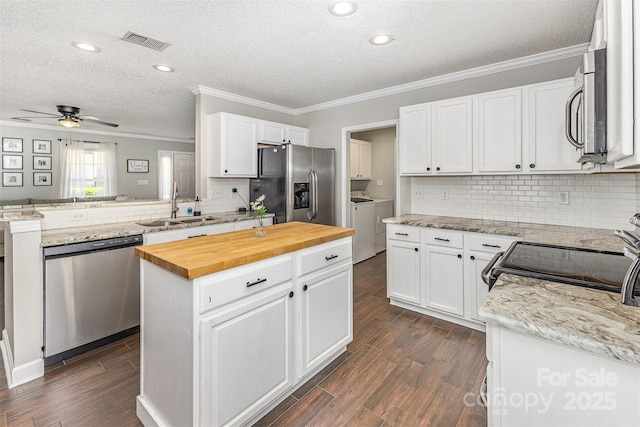 197 Devon Forest Dr, Mooresville, NC 28115 - kitchen with appliances with stainless steel finishes, separate washer and dryer, a sink, butcher block counters, and crown molding