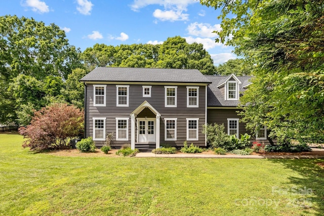 5229 Mt Holly Huntersville Rd, Charlotte, NC 28216 - colonial house featuring a front lawn, view of scattered trees, and roof with shingles