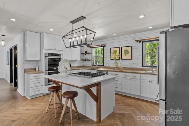 5229 Mt Holly Huntersville Rd, Charlotte, NC 28216 - kitchen with stainless steel appliances, white cabinetry, recessed lighting, a sink, and a center island