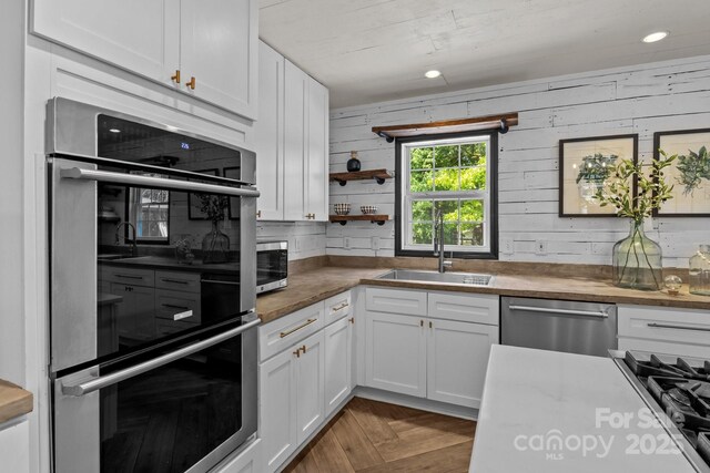 5229 Mt Holly Huntersville Rd, Charlotte, NC 28216 - kitchen featuring appliances with stainless steel finishes, a sink, white cabinets, and open shelves
