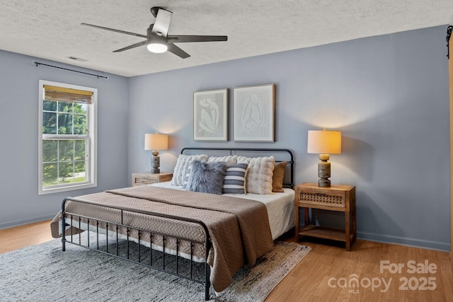 5229 Mt Holly Huntersville Rd, Charlotte, NC 28216 - bedroom featuring a textured ceiling, wood finished floors, baseboards, and a ceiling fan