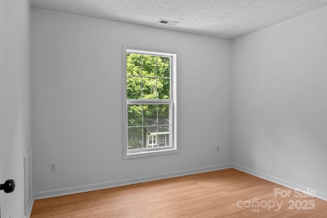 5229 Mt Holly Huntersville Rd, Charlotte, NC 28216 - unfurnished room with light wood finished floors, a textured ceiling, and baseboards