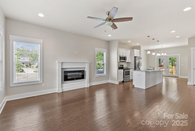 7 Lola Lilly Pl, Asheville, NC 28803 - unfurnished living room featuring healthy amount of natural light, dark wood-style floors, a glass covered fireplace, and recessed lighting